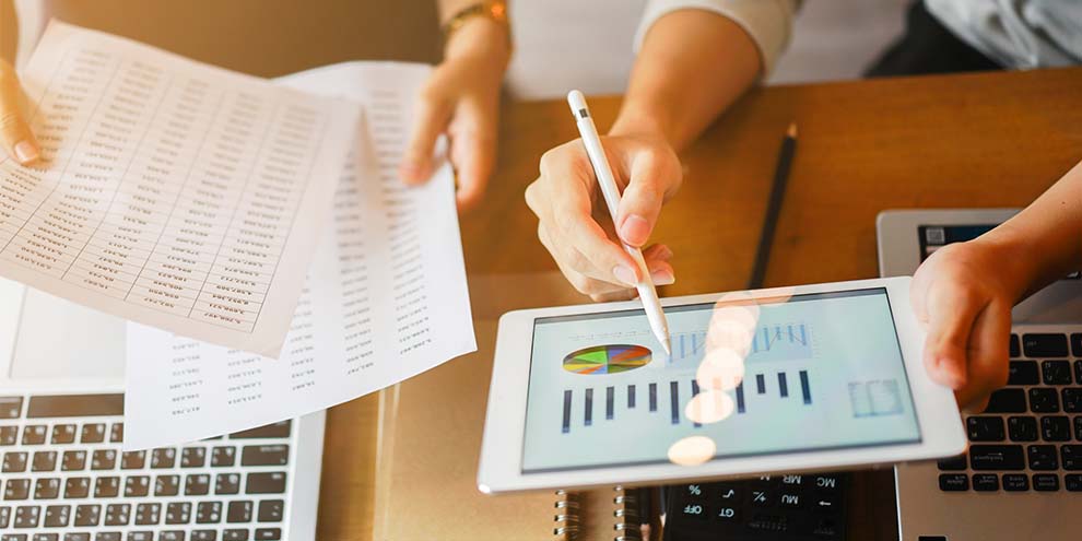 Two People Looking Data On Paper And Tablet