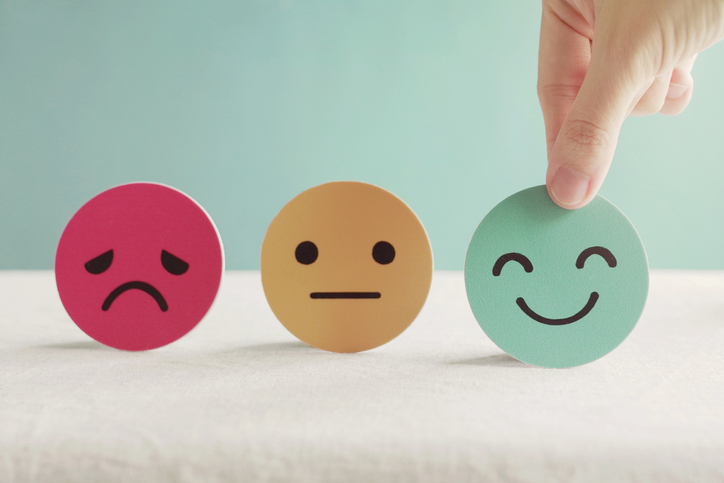 Hand Choosing Green Happy Smiley Face Paper Cut Out