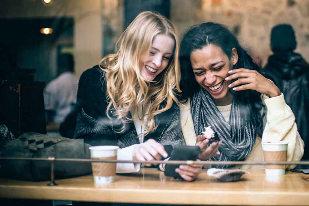 Two Humans Looking At Smartphone And Laughing