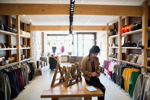 Business Owner Texting With Cell Phone In Shop Picture Id583665337