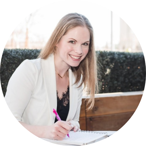 Photo of Amanda Ilnisky smiling at the camera while writing in a notebook outdoors.