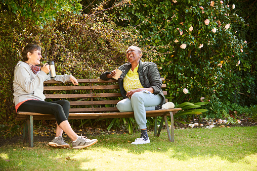 Two Senior Female Friends Talking And Laughing Together Over Coffees