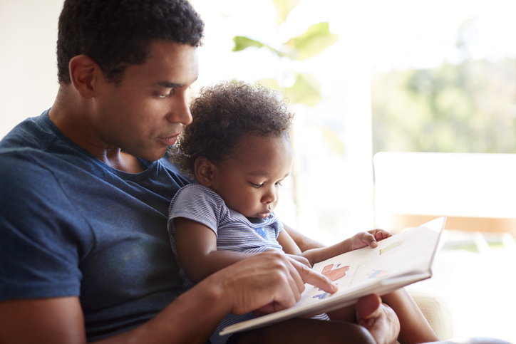 Father Reading A Book With His Two Year Old Son