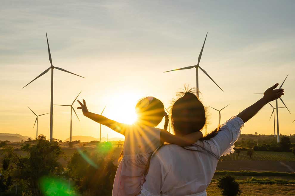 A Mother Holding Her Daughter In Front Of Windmills